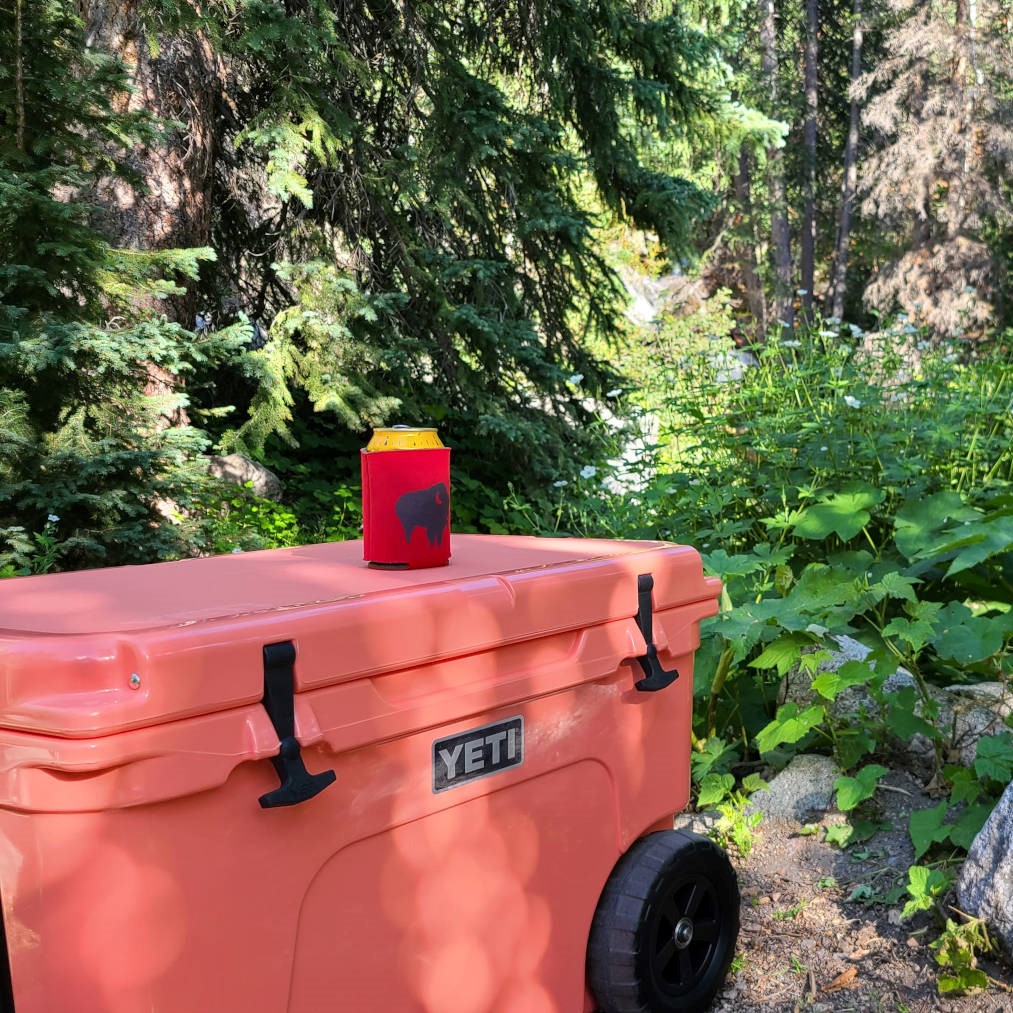 A Yeti camping cooler with food in it and beverage on top at the campsite - HelloTrail.com