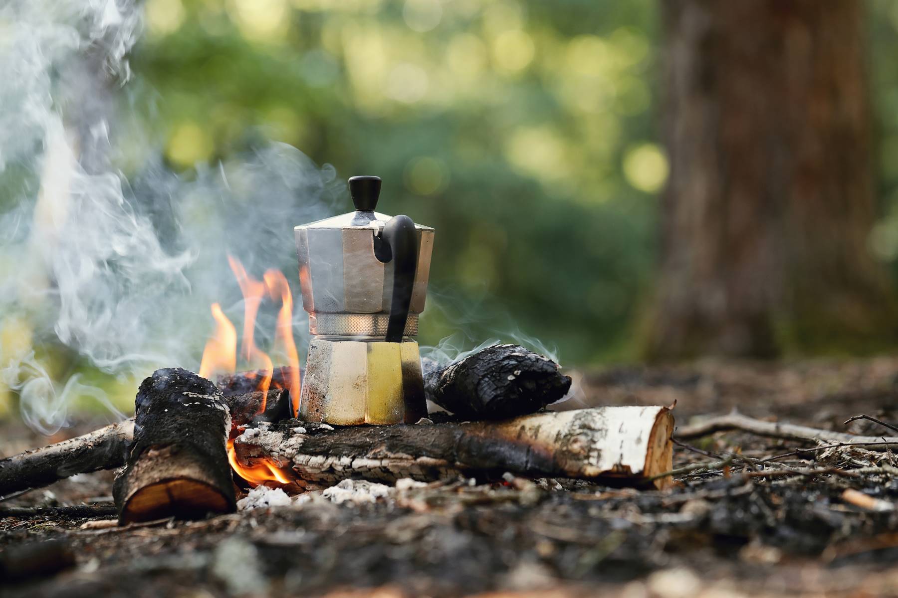 Campfire coffee pot heating up on an open fire