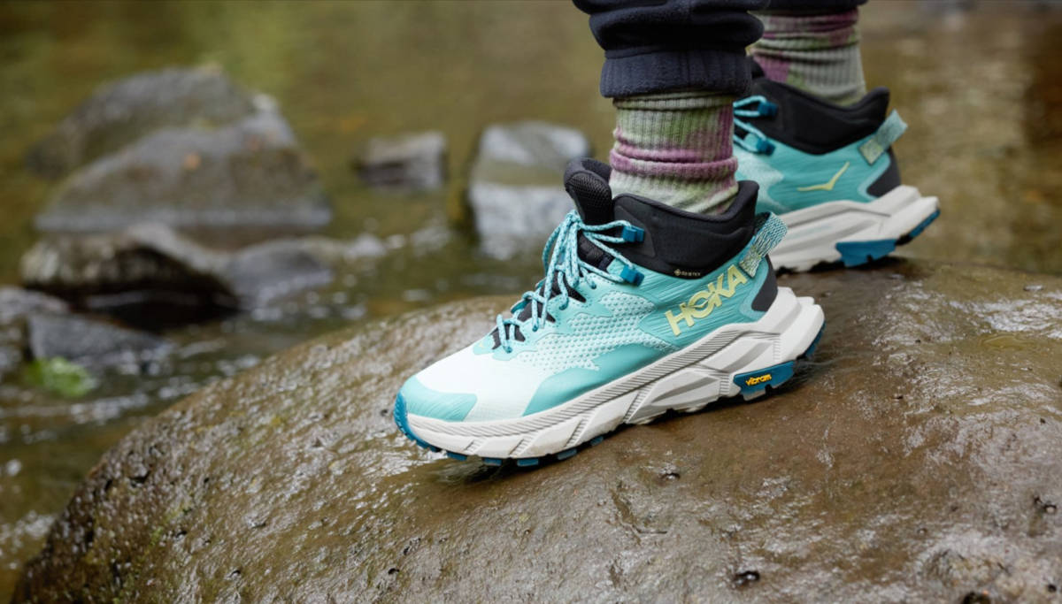 Wearing the women's Hoka Trail Code GTX hiking boots on a wet rock near water